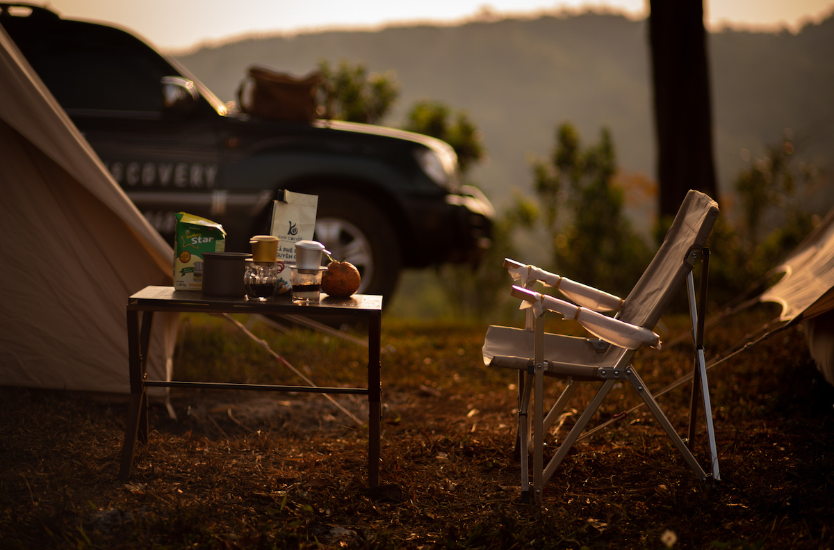 bàn ghế và đồ dùng trong không gian camping Măng Đen lúc chiều tối