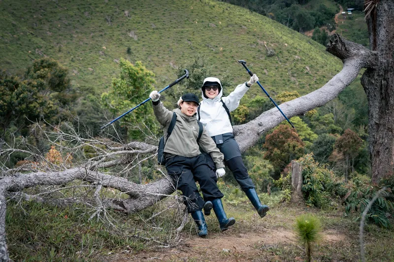 Hai khách nghỉ trên thân cây trong cung trekking Kon Tu Ma