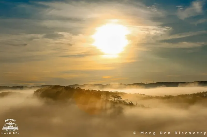 mặt trời vừa lên trong cảnh bình minh tại Măng Đen được du khách chụp lại sau khi săn mây, làn mây còn chưa tan xen kẽ từng tán cây rừng xung quanh các ngọn núi