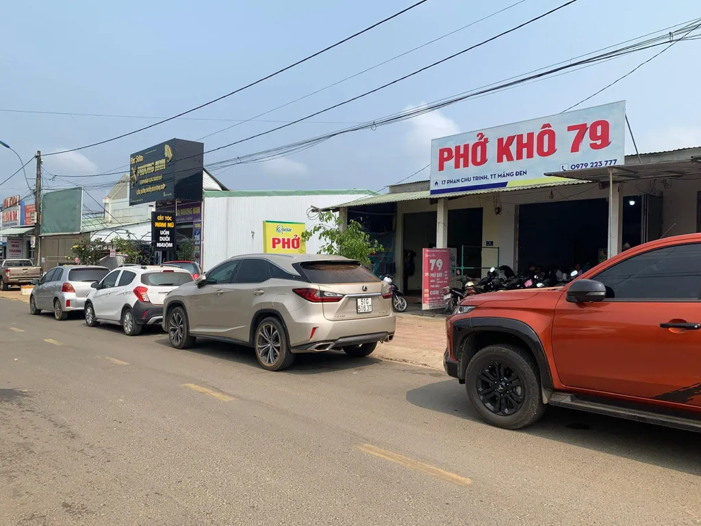 Phở Kh&ocirc; 79 Măng Đen nh&igrave;n từ ngo&agrave;i đường với xe đậu trước qu&aacute;n v&agrave;o giờ s&aacute;ng