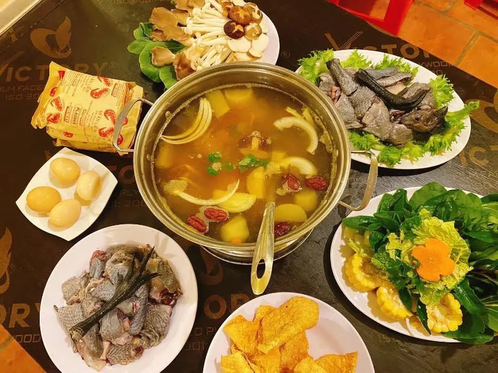 Nồi lẩu đang nấu tại Nấm Nh&agrave; L&agrave;nh Măng Đen với nước d&ugrave;ng chia hai ngăn