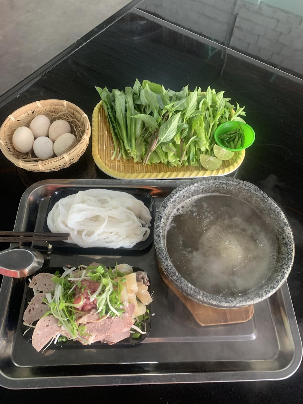 một phần phở bát đá với bát đá sôi, thịt bò và bánh phở ở Măng Đen