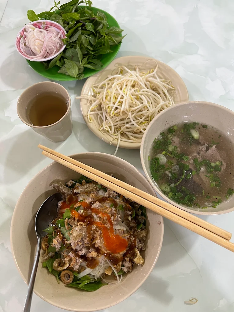 Một phần phở kh&ocirc; 2 t&ocirc; tại Qu&aacute;n B&agrave; Bảy Măng Đen gồm t&ocirc; trộn, t&ocirc; nước d&ugrave;ng v&agrave; rau ăn k&egrave;m