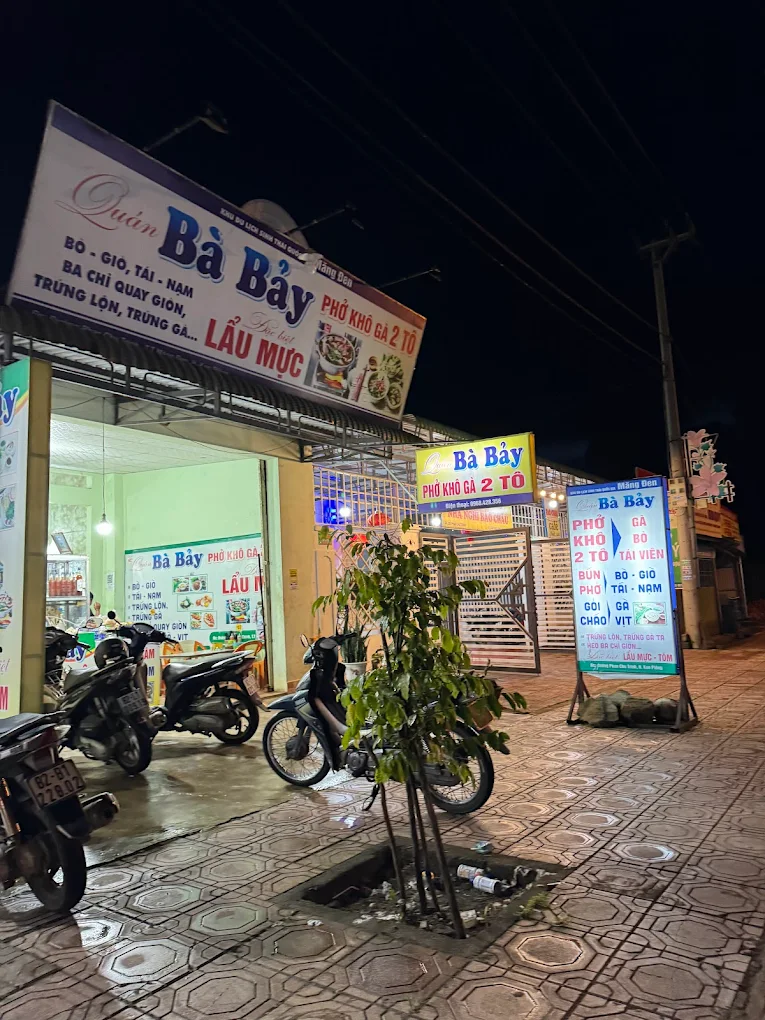 Qu&aacute;n B&agrave; Bảy Măng Đen v&agrave;o buổi tối với bảng hiệu s&aacute;ng đ&egrave;n ph&iacute;a trước
