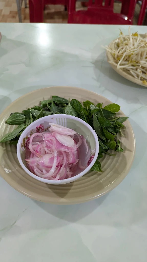 Đĩa h&agrave;nh ng&acirc;m c&ugrave;ng rau thơm ăn k&egrave;m phở tại Qu&aacute;n B&agrave; Bảy Măng Đen